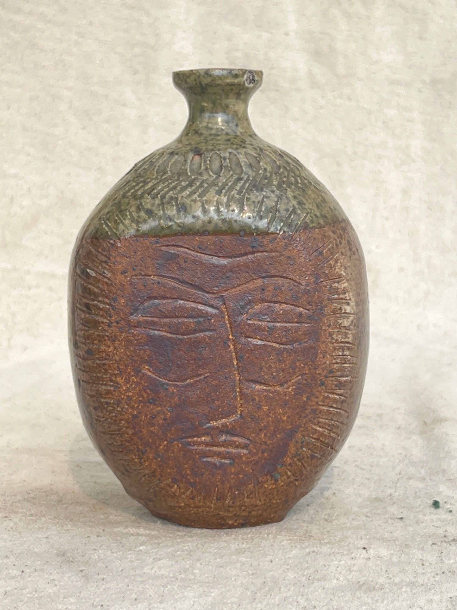 Ceramic stoneware bud vase with engraved face design by E. Harris, featuring earthy tones and artistic texture — Hommes and Gardens, Vases + Vessels Collection, home decor, outdoor decorations, home design, luxury design, Landscape Architect, Interior Designer, Outdoor Living, Art, Furniture, Objects, Best Gifts, Nature, Backyard, Yard.
