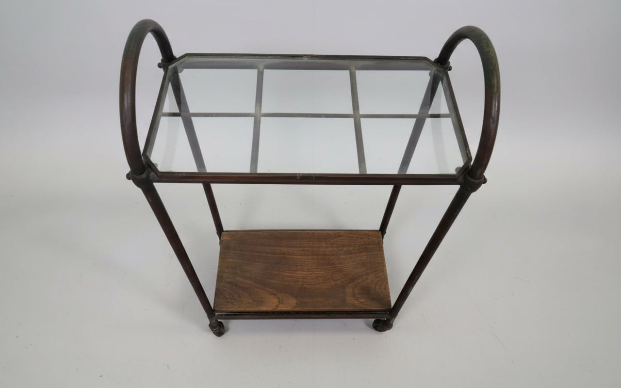 Side view of antique industrial entryway stand showing curved copper frame, glass top, and lower wooden shelf — Hommes and Gardens, Home Decor Collection, Furniture, landscape design, plant design, Landscape Architect, Interior Designer, Outdoor Living, Outdoor Decorations, Home Design, Luxury Design, Art, Furniture, Objects, Best Gifts, Nature, Backyard, Yard.
