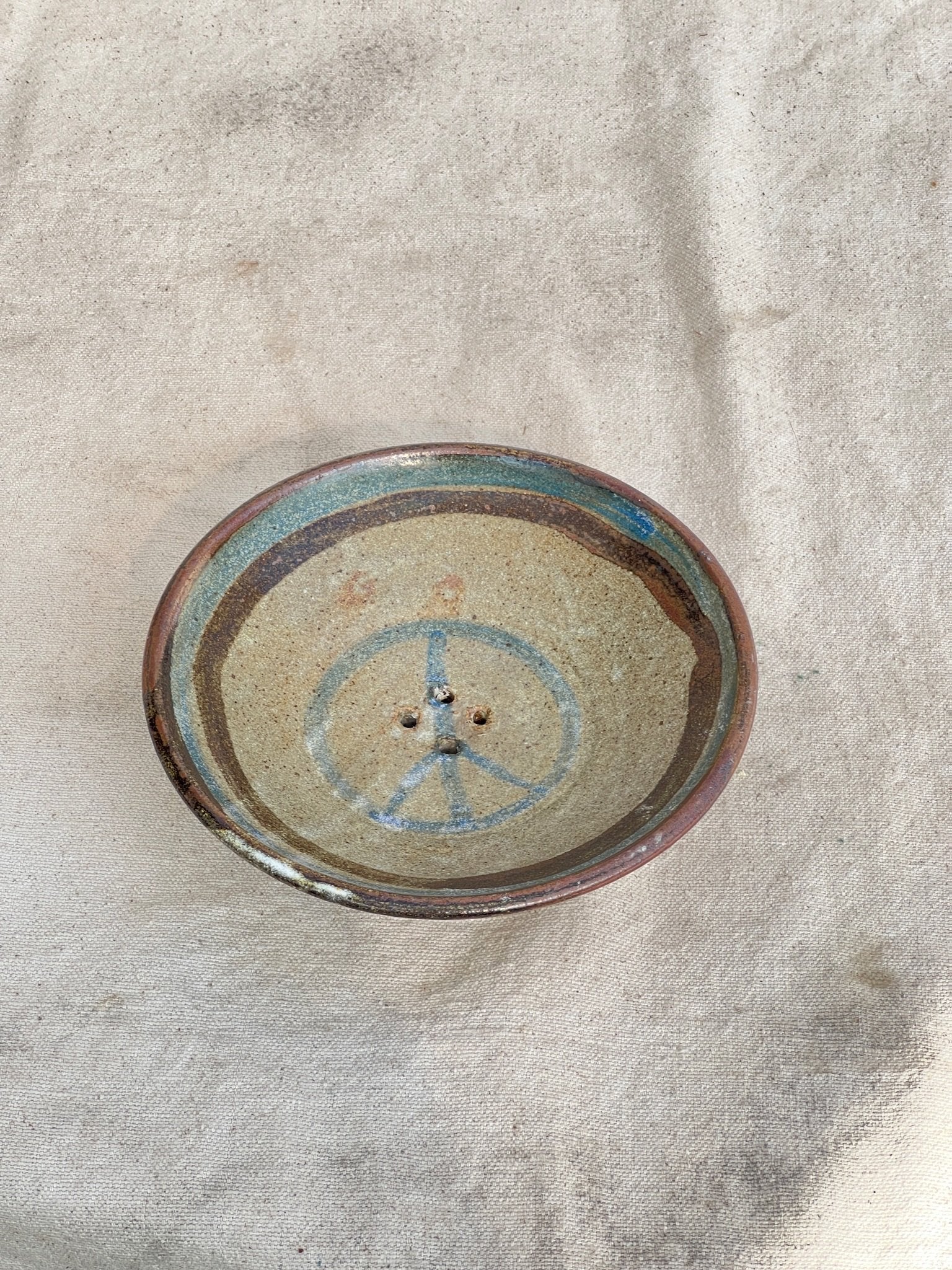 Handmade signed pottery plate with small drainage holes, artisan ceramic strainer ideal for kitchen or display — Hommes and Gardens, Home Decor Collection, Pottery Art, Decorative Bowls, Functional Decor, Rustic Kitchenware, Artistic Pottery.