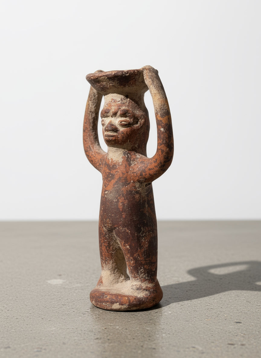 Side angle of Pre-Columbian terracotta ritual figure with raised arms holding an offering bowl, showing weathered brown surface and handmade details — Hommes and Gardens, Home Decor, landscape design, plant design, Landscape Architect, Interior Designer, Outdoor Living, Outdoor Decorations, Home Design, Luxury Design, Art, Furniture, Objects, Best Gifts, Nature, Backyard, Yard.