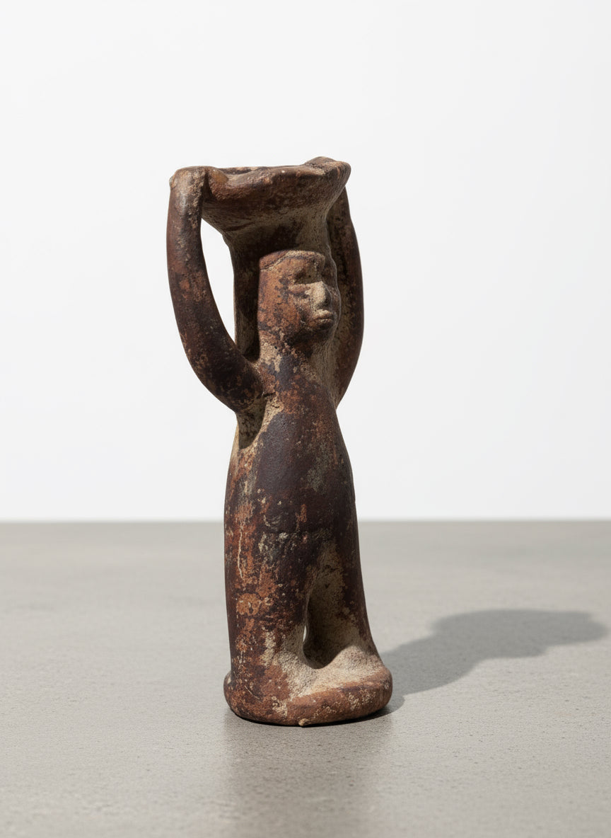 Three-quarter view of Pre-Columbian terracotta ritual figure with raised arms supporting an offering bowl, showing aged surface texture and handcrafted folk art details — Hommes and Gardens, Home Decor, landscape design, plant design, Landscape Architect, Interior Designer, Outdoor Living, Outdoor Decorations, Home Design, Luxury Design, Art, Furniture, Objects, Best Gifts, Nature, Backyard, Yard.