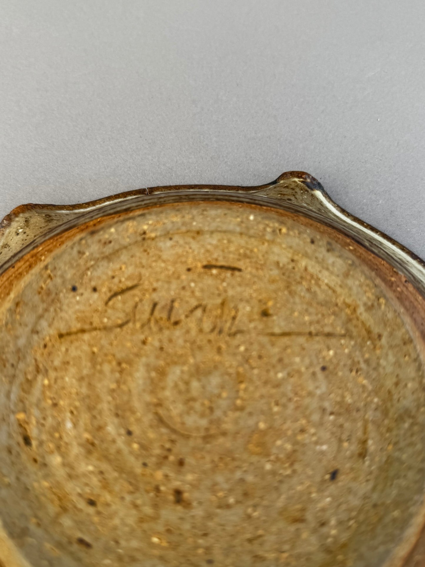 Close-up of signed studio pottery ceramic ashtray showing artist’s mark on the textured earth tone base — Hommes and Gardens, Home Decor Collection, landscape design, plant design, Landscape Architect, Interior Designer, Outdoor Living, Outdoor Decorations, Home Design, Luxury Design, Art, Furniture, Objects, Best Gifts, Nature, Backyard, Yard.