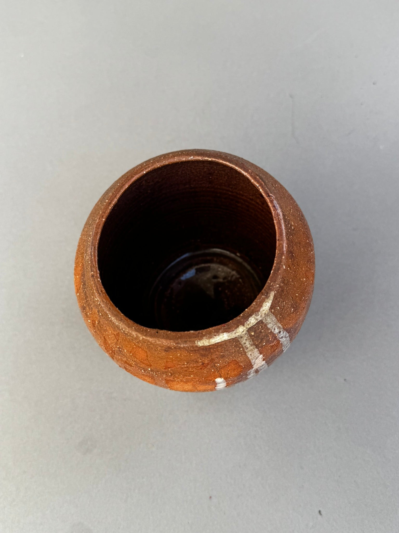 Top view of signed Buhrandt studio pottery cup showing handcrafted stoneware interior and abstract terracotta glaze — Hommes and Gardens, Home Decor Collection, landscape design, plant design, Landscape Architect, Interior Designer, Outdoor Living, Outdoor Decorations, Home Design, Luxury Design, Art, Furniture, Objects, Best Gifts, Nature, Backyard, Yard.