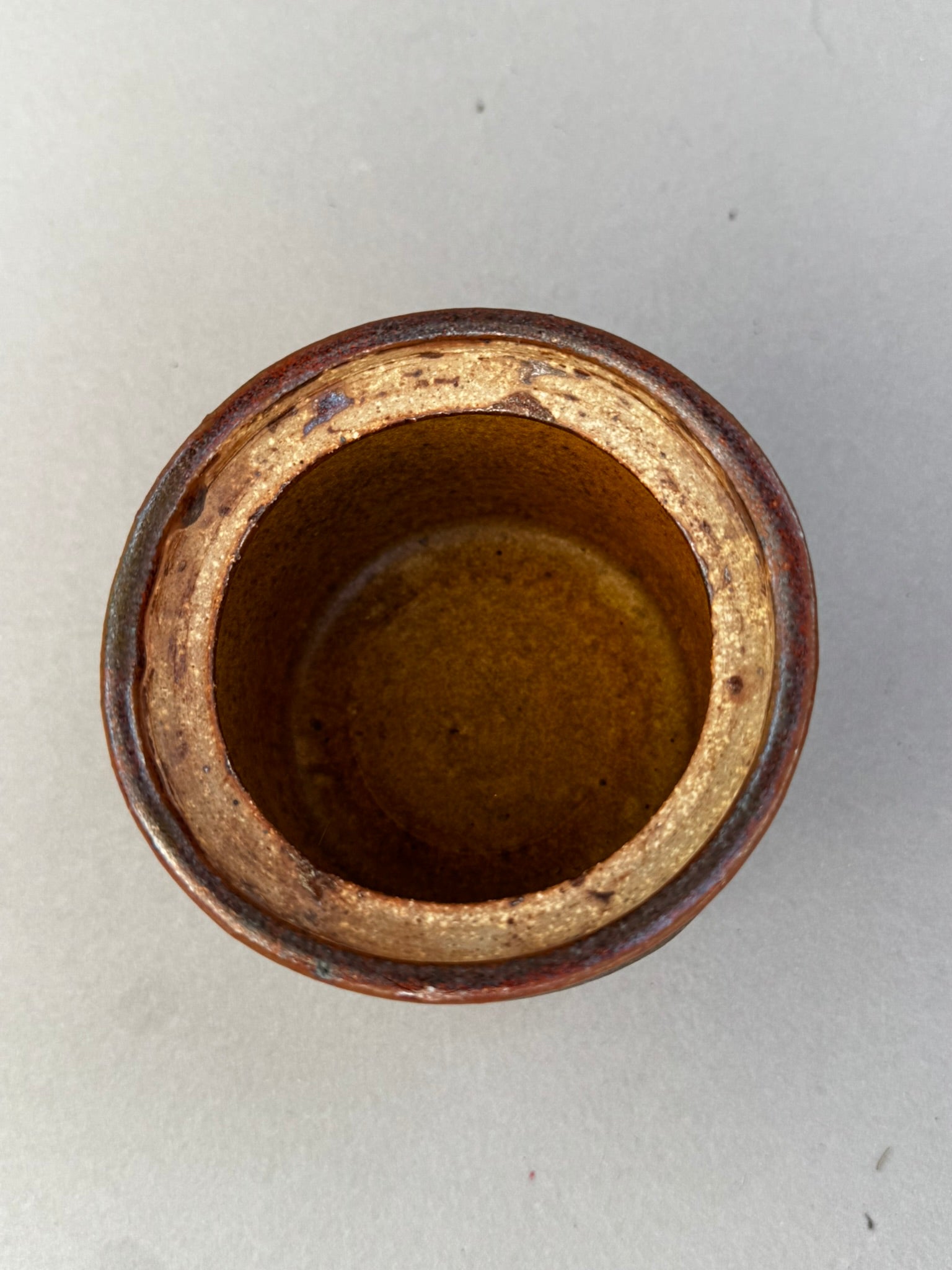 Top view of handmade mid-century modern studio pottery vessel showing golden ochre glazed interior and textured rim — Hommes and Gardens, Home Decor Collection, landscape design, plant design, Landscape Architect, Interior Designer, Outdoor Living, Outdoor Decorations, Home Design, Luxury Design, Art, Furniture, Objects, Best Gifts, Nature, Backyard, Yard.