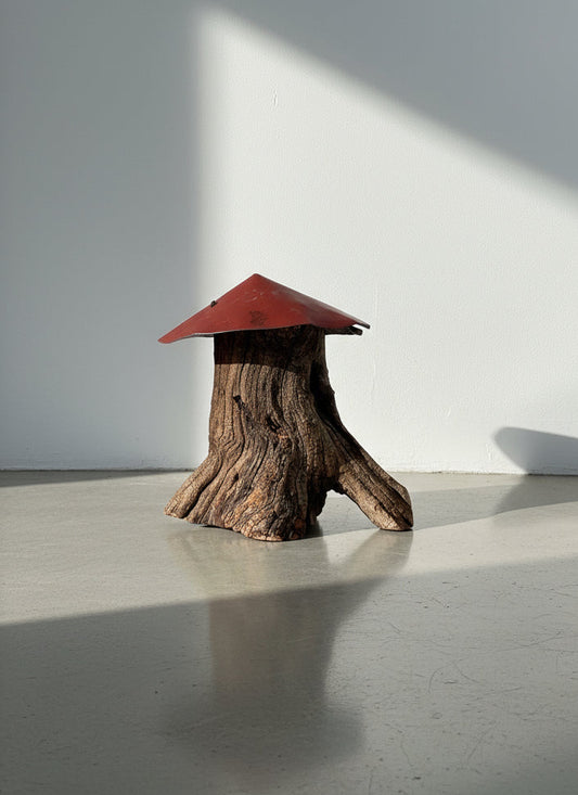 Tree stump mushroom sculpture handcrafted from weathered wood with a red metal roof, featuring organic rustic texture and primitive folk art craftsmanship — Hommes and Gardens, Home Decor Collection, landscape design, plant design, Landscape Architect, Interior Designer, Outdoor Living, Outdoor Decorations, Home Design, Luxury Design, Art, Furniture, Objects, Best Gifts, Nature, Backyard, Yard.