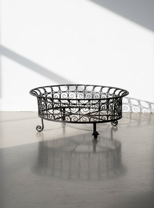 Victorian oval wrought iron plant holder with ornate scrollwork and natural patina, elegant antique garden display inspired by 19th-century French design — Hommes and Gardens, Furniture Collection, Plant Cages & Supports, Vintage Garden Decor, Wrought Iron Furniture, Rustic Outdoor Accent, Antique Botanical Stand.