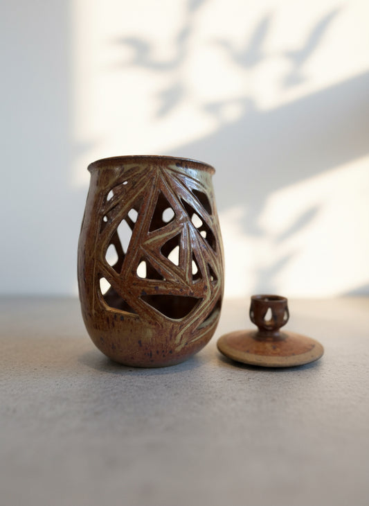 Vintage ceramic vase with lid and geometric cutout design, finished in warm earthy brown glaze with sculptural form, front view — Hommes and Gardens, Home Decor Collection, landscape design, plant design, Landscape Architect, Interior Designer, Outdoor Living, Outdoor Decorations, Home Design, Luxury Design, Art, Furniture, Objects, Best Gifts, Nature, Backyard, Yard.
