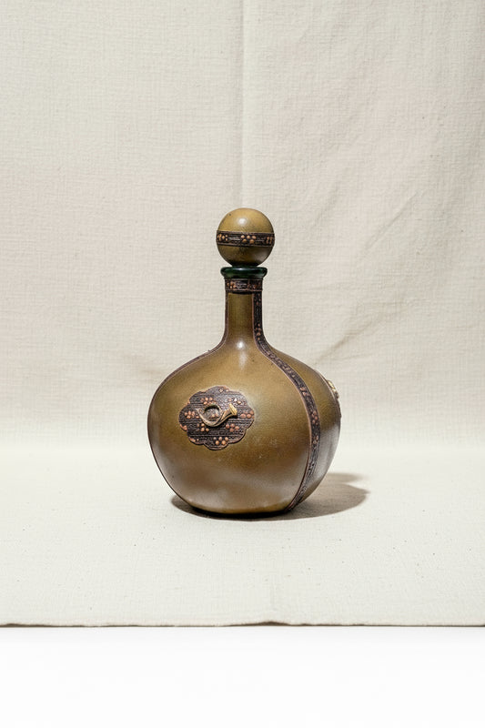 Vintage Italian green leather-wrapped decanter with a musical horn emblem, elegant collectible for classic bar decor — Hommes and Gardens, Home Decor Collection, Decanters, Vintage Barware, Italian Leather Art, Decorative Objects, Retro Drinkware, Gift for Collectors.