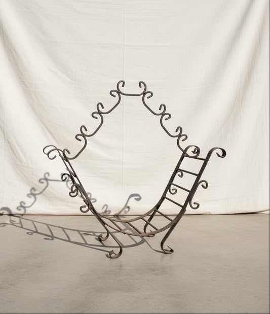 Vintage wrought iron firewood holder featuring an open frame and sturdy construction, combining rustic charm with timeless functionality for home interiors — Hommes and Gardens, Home Decor Collection, Firewood Holders, Decorative Objects, Vintage Ironwork, Rustic Fireplace Accessories, Antique Metal Decor, Classic Home Styling, Hearth Design Accent.