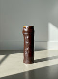 Brown ceramic vase on a textured gray background