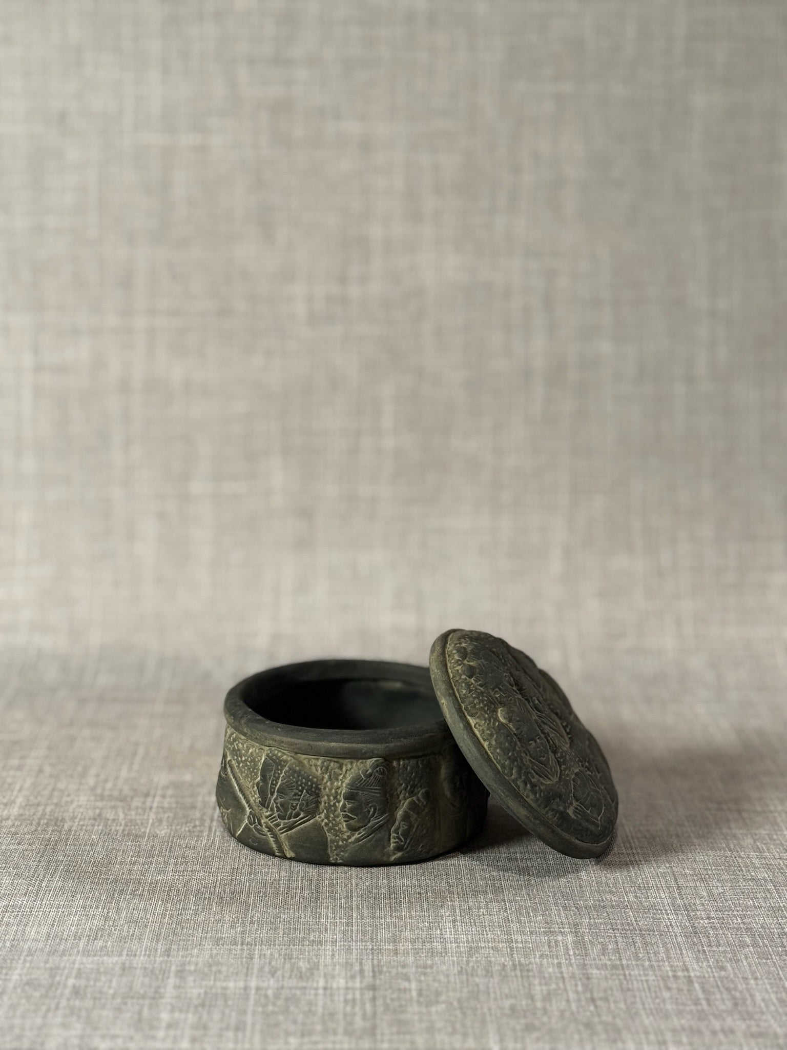 Hand-Carved Dark Grey Terracotta Lidded Vessel with Tribal Portrait Reliefs & Horse Motif