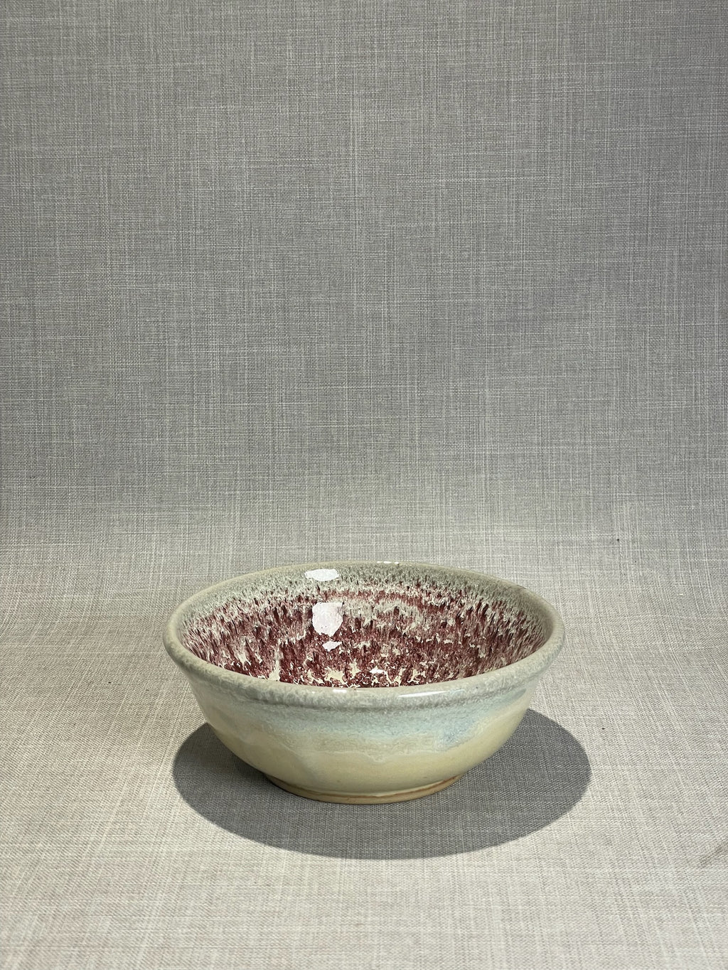 Artisan Studio Pottery Bowl with Red Speckled Drip-Glaze Interior and Soft Neutral Exterior