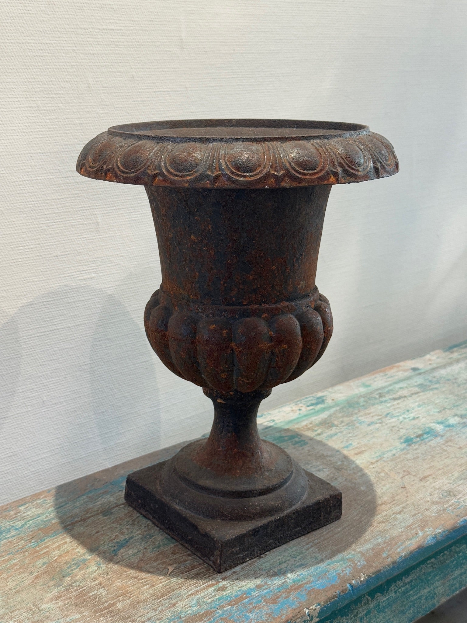 Antique French Neoclassical Cast Iron Mini Urn Planter – Aged Patina on a rustic table at hommes + gardens estudio.