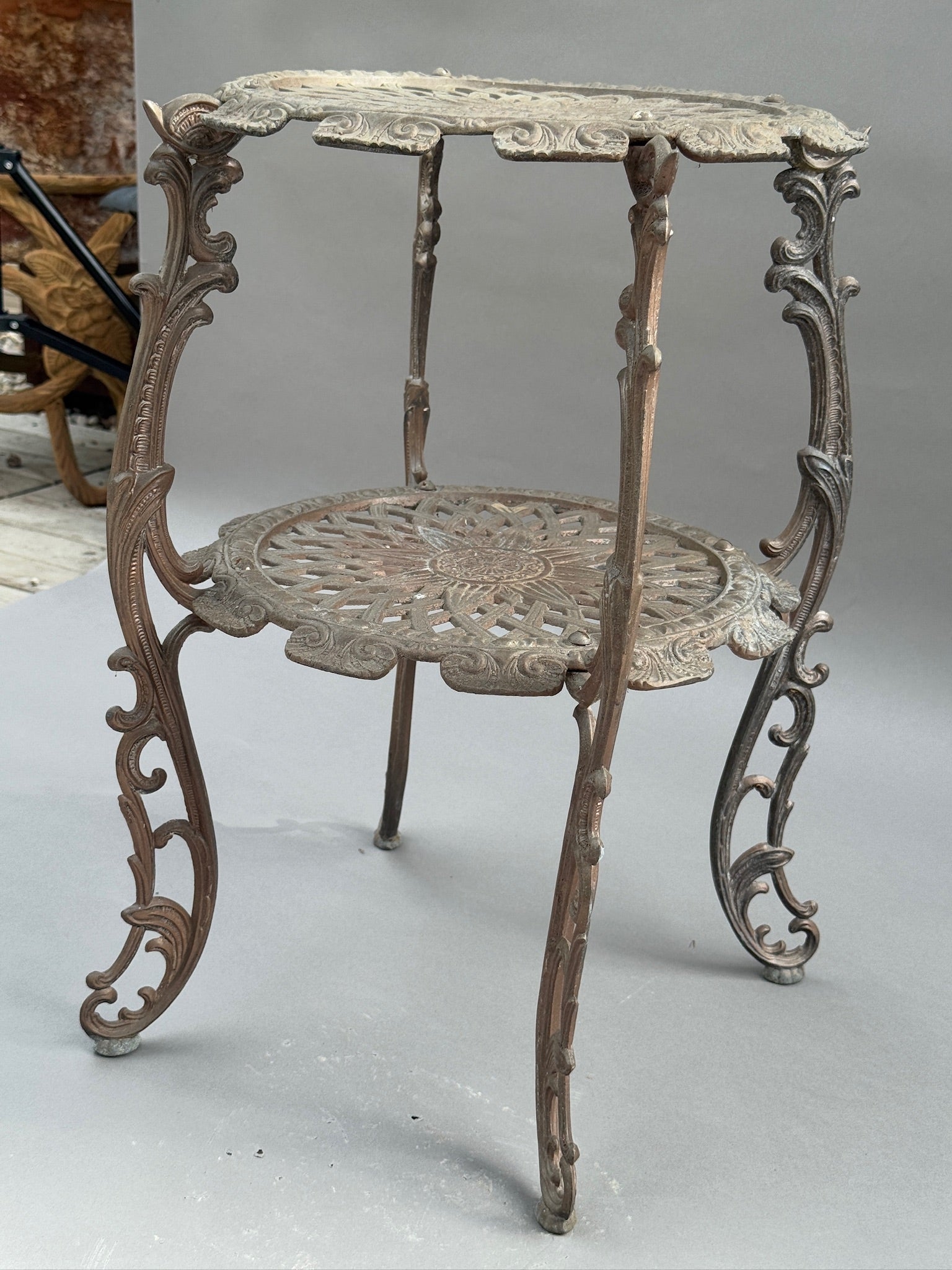 Ornate Victorian Revival Cast Iron Two-Tier Plant Stand with Pierced Floral Design showcasing intricate scrollwork and floral motifs. hommes + gardens estudio.