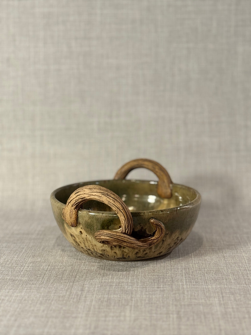 handmade ceramic bowl with sculptural handles and textured surface