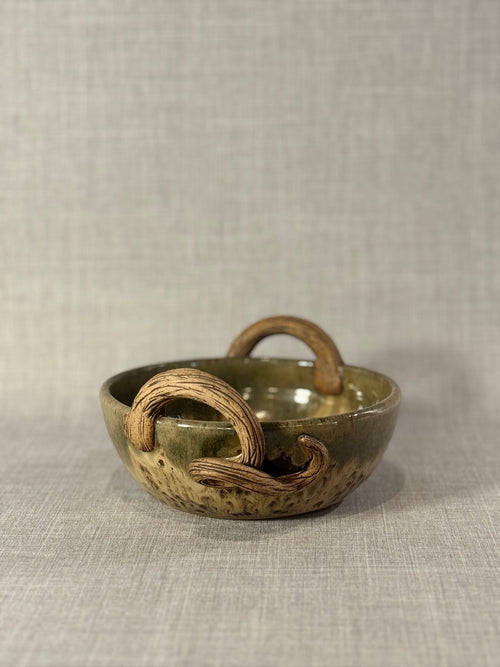 handmade ceramic bowl with sculptural handles and textured surface