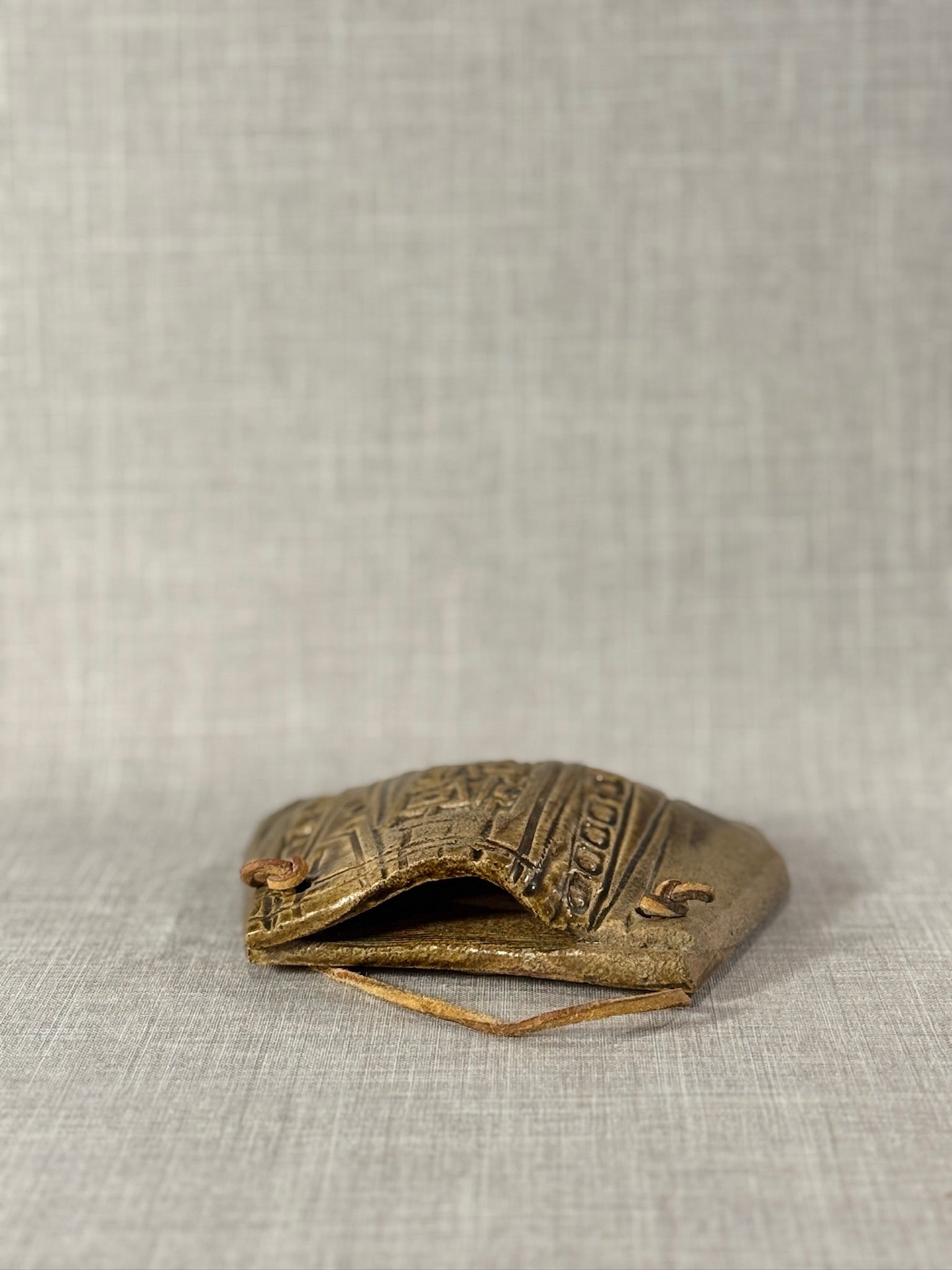 Decorative Ceramic Handbag Wall Sculpture with Leather Strap showcasing artisan craftsmanship and tribal patterns. hommes + gardens estudio.