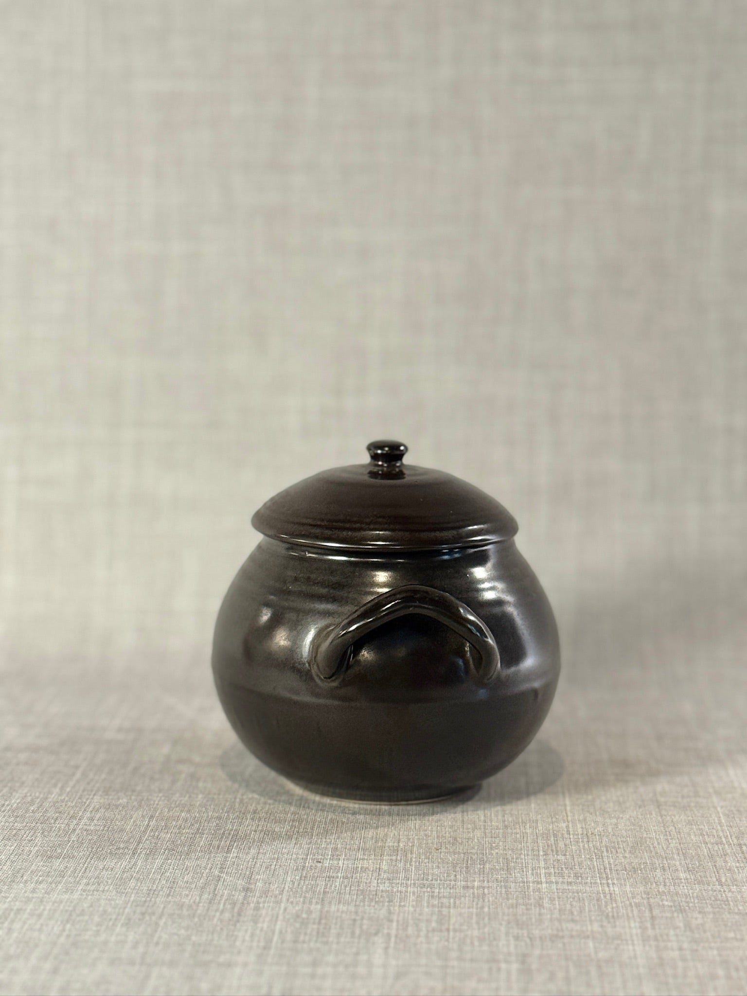 Mid-Century Black Glazed Studio Pottery Bean Pot with Lid and Sculpted Handles