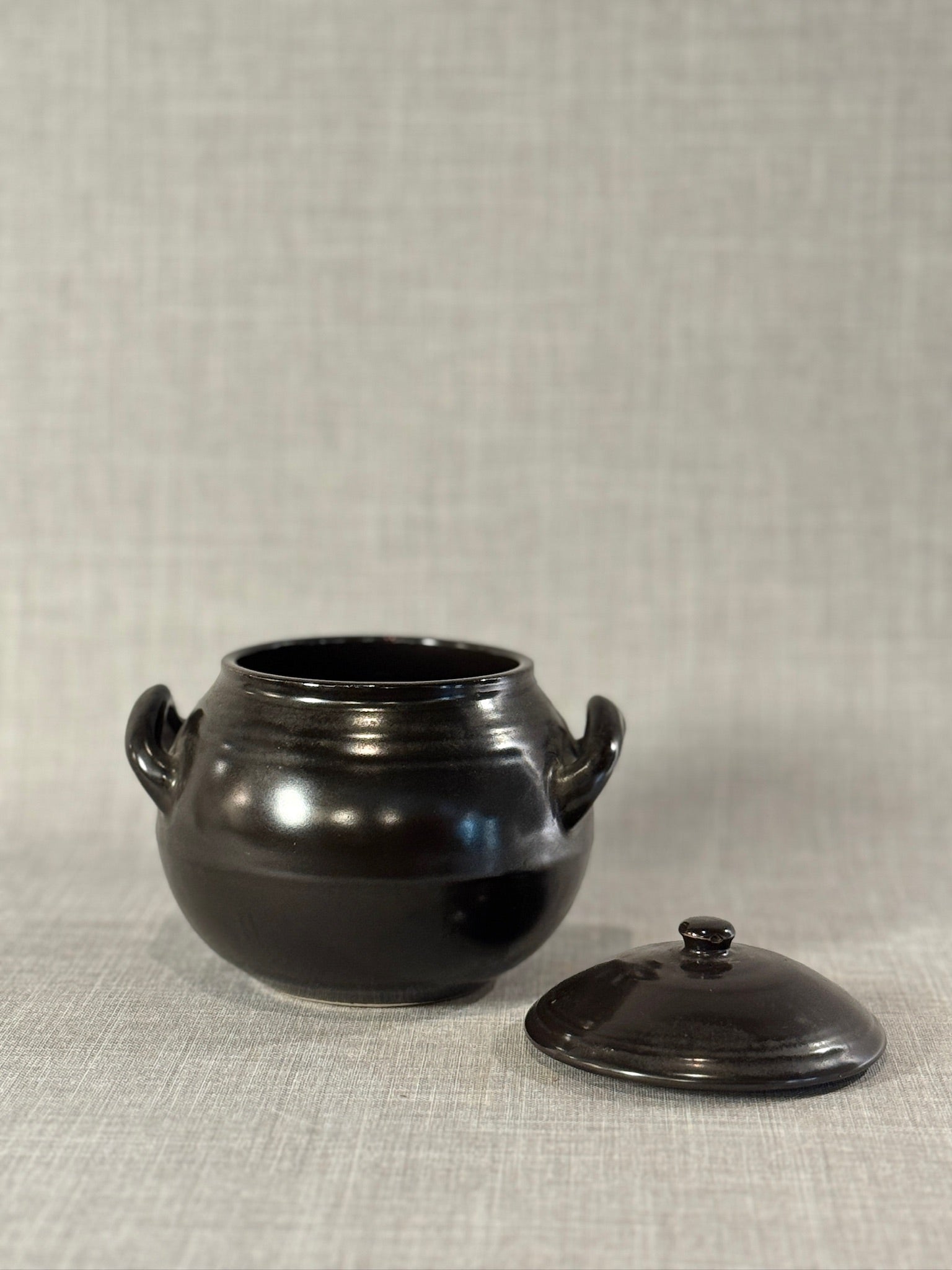 Mid-Century Black Glazed Studio Pottery Bean Pot with Lid and Sculpted Handles