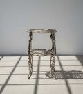 Ornate Victorian Revival Cast Iron Two-Tier Plant Stand with Pierced Floral Design in natural light, showcasing intricate details. hommes + gardens estudio.