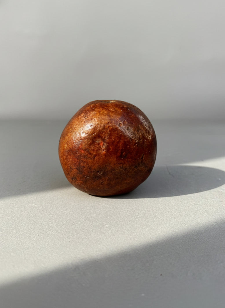 Primitive Handcrafted Clay Bead – Ethnic Red-Brown Ceramic Artifact with Pierced Center, showcasing earthy tones. hommes + gardens estudio.