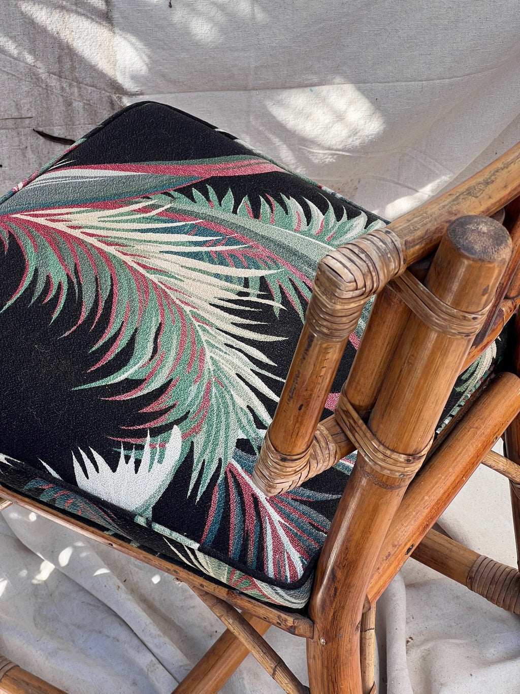 Rattan Bistro Table with Black Glass Top featuring a chair with Hollywood Palm upholstery, vintage style. hommes + gardens estudio.