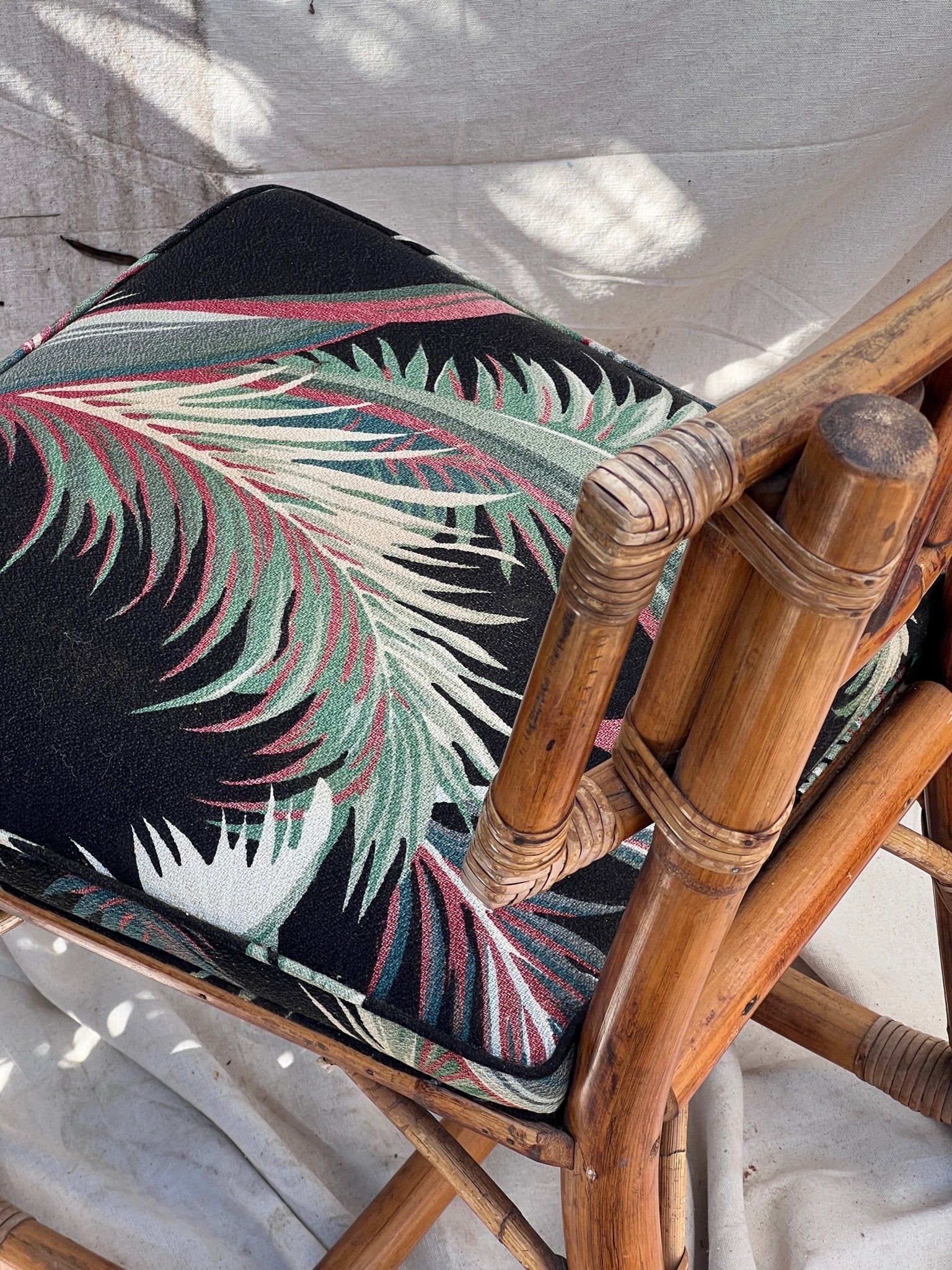 Rattan Bistro Table with Black Glass Top featuring a chair with Hollywood Palm upholstery, vintage style. hommes + gardens estudio.