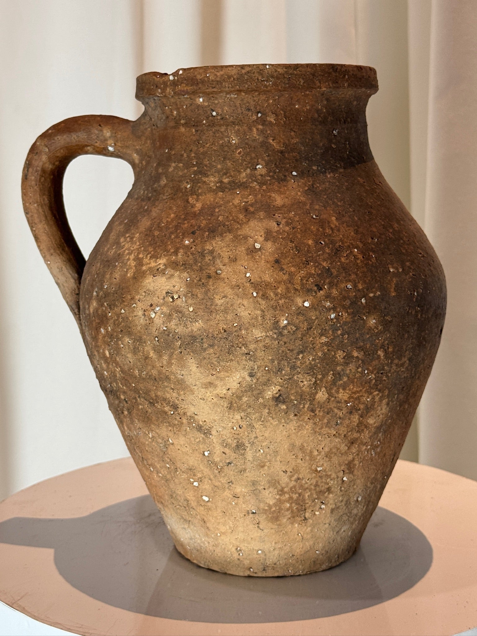 Antique handcrafted terracotta pot with amphora-style design and single handle, showcasing earthy brown tones, weathered patina, and timeless rustic charm — Hommes and Gardens, Pots + Planters Collection, Landscape Architect, Interior Designer, Outdoor Living, Art, Furniture, Objects, Best Gifts, Nature, Backyard, Yard, Outdoor Decorations, Home Decor, Home Design, Luxury Design.