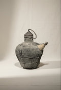 Antique Southeast Asian Kendi water pot crafted from wood and rattan in black and brown tones, a ceremonial vessel symbolizing regional artistry and cultural heritage — Hommes and Gardens, Home Decor Collection, Outdoor Decorations, Landscape Architect, Interior Designer, Outdoor Living, Home Design, Luxury Design, Art, Furniture, Objects, Best Gifts, Nature, Backyard, Yard.