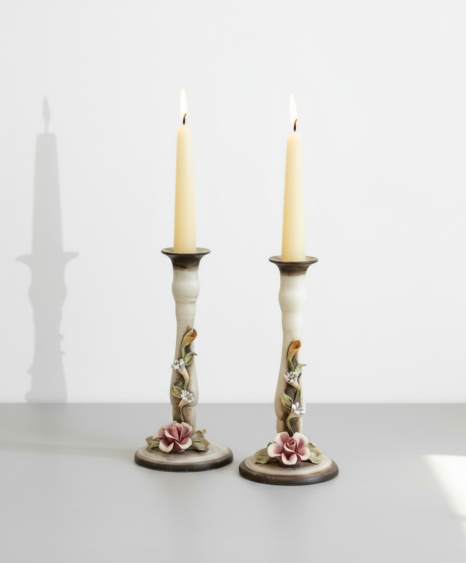 Pair of Ceramic Candlesticks with Floral Decoration featuring detailed floral designs and lit candles, hommes + gardens estudio.
