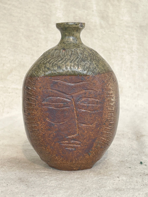 Ceramic stoneware bud vase with engraved face design by E. Harris, featuring earthy tones and artistic texture — Hommes and Gardens, Vases + Vessels Collection, home decor, outdoor decorations, home design, luxury design, Landscape Architect, Interior Designer, Outdoor Living, Art, Furniture, Objects, Best Gifts, Nature, Backyard, Yard.