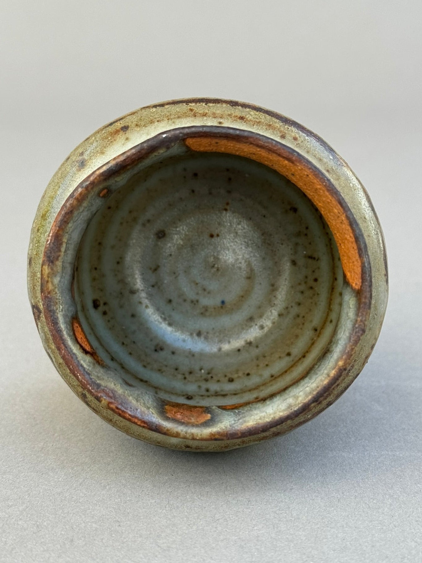 Close-up view of the Signed Studio Pottery Urn Vase P.S.E – Brown, Gray & Terracotta Ash Glaze showing intricate glaze details. hommes + gardens estudio.