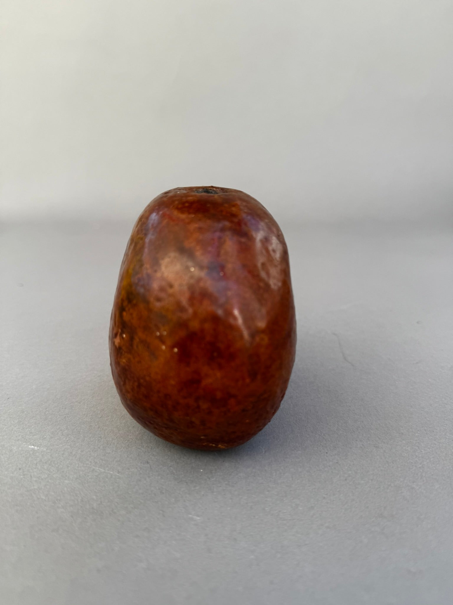 Primitive Handcrafted Clay Bead – Ethnic Red-Brown Ceramic Artifact with Pierced Center, showing earthy tones and texture. hommes + gardens estudio.