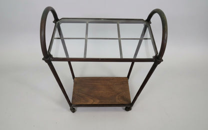 Side view of antique industrial entryway stand showing curved copper frame, glass top, and lower wooden shelf — Hommes and Gardens, Home Decor Collection, Furniture, landscape design, plant design, Landscape Architect, Interior Designer, Outdoor Living, Outdoor Decorations, Home Design, Luxury Design, Art, Furniture, Objects, Best Gifts, Nature, Backyard, Yard.