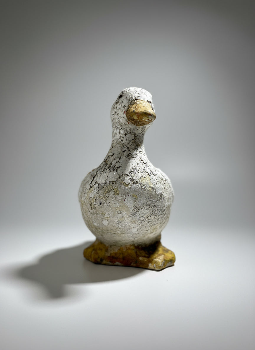 Weathered Vintage Concrete Duck Garden Sculpture – Rustic Folk Art Décor in aged white and yellow tones, perfect for garden decor. hommes + gardens estudio.