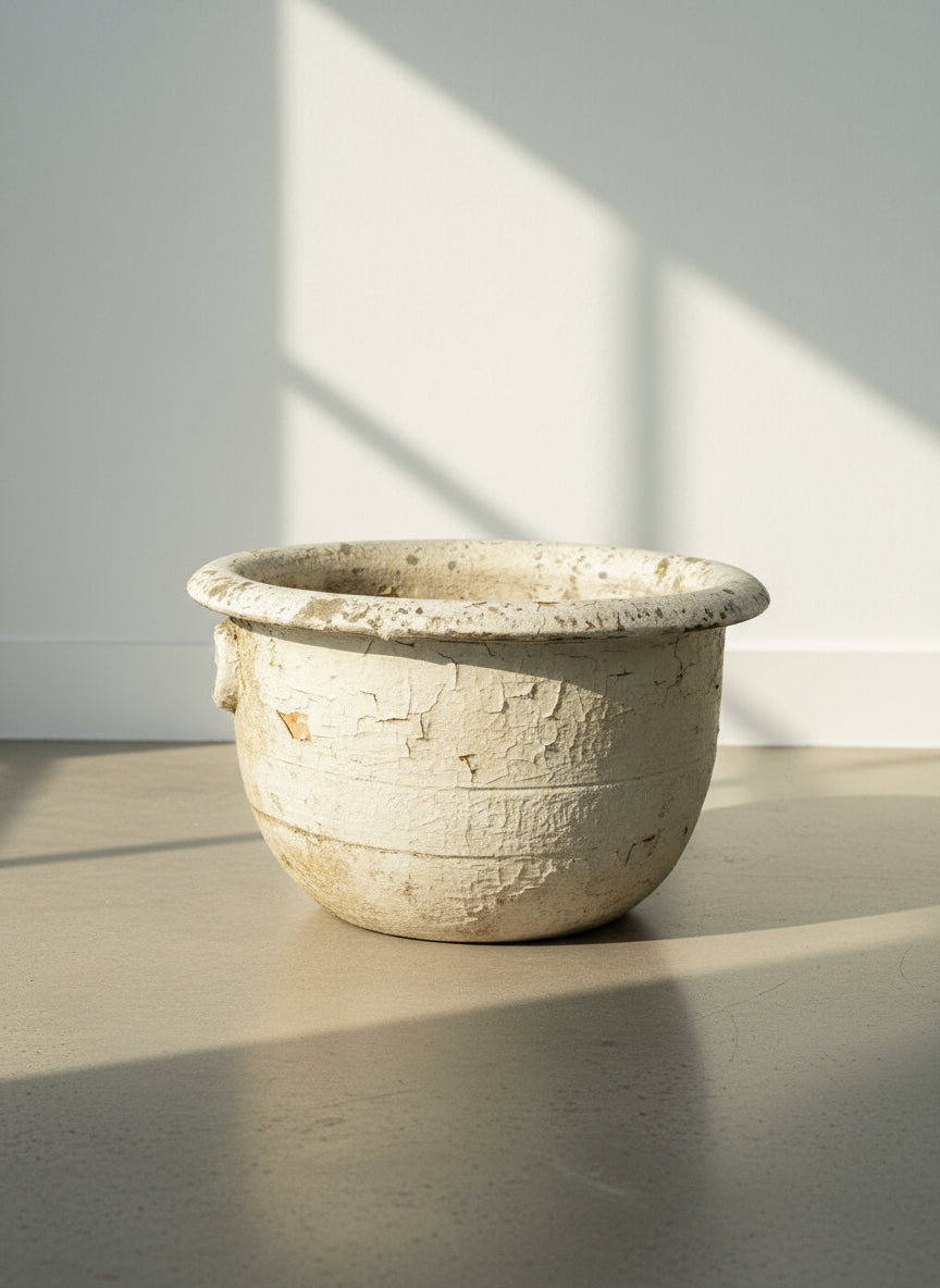 Antique European Terracotta Planter with Aged White Patina resting on a floor, showcasing its rustic charm and weathered finish. hommes + gardens estudio.