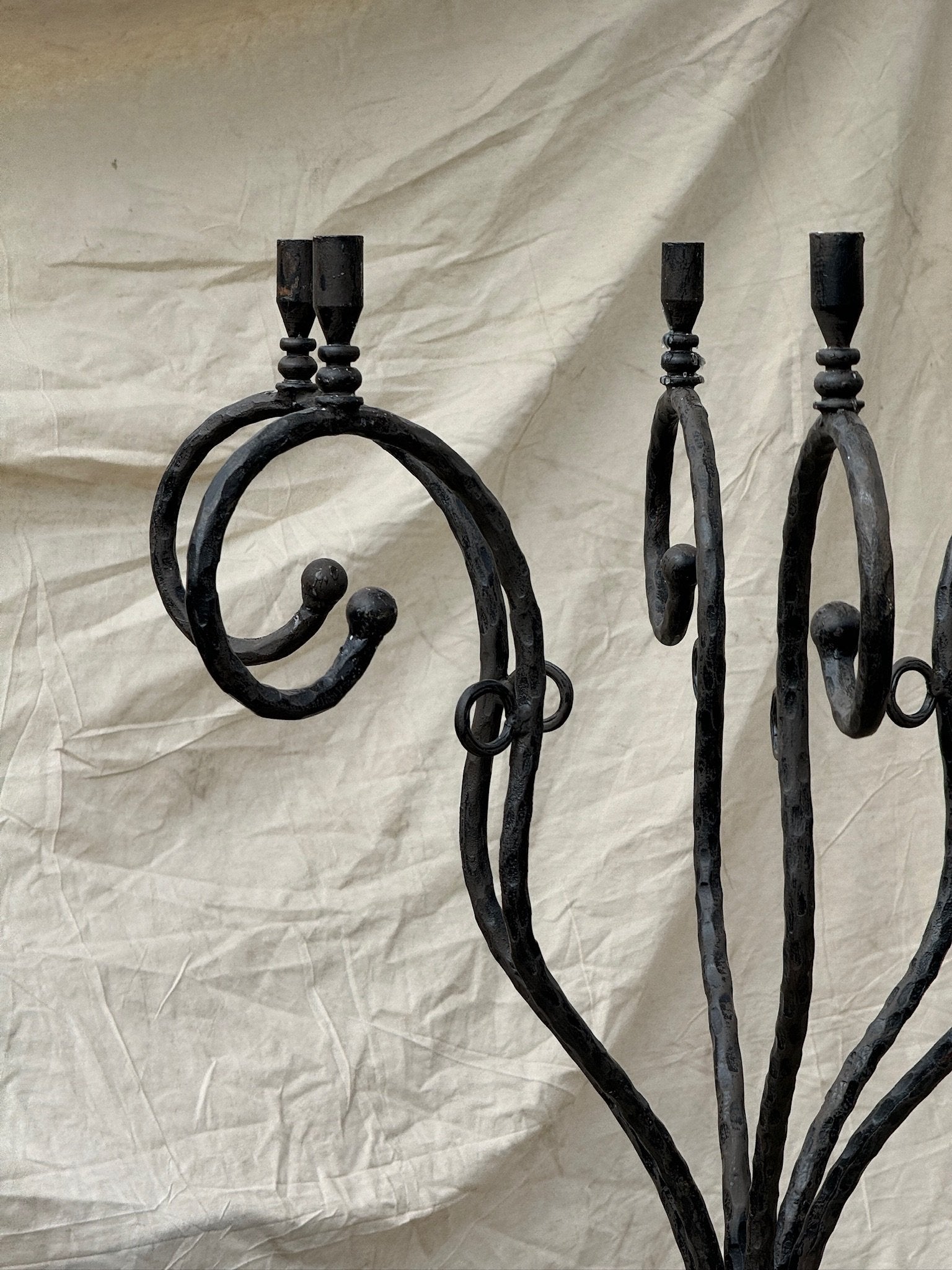 Vintage Scrolled Cast Iron Candelabrum with intricate scrolled arms against a neutral backdrop, hommes + gardens estudio.