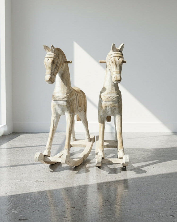 Antique Hand-Carved Wooden Rocking Horses – Rustic Folk Art Pair, 23” & 15.5” displayed in a bright room. hommes + gardens estudio.