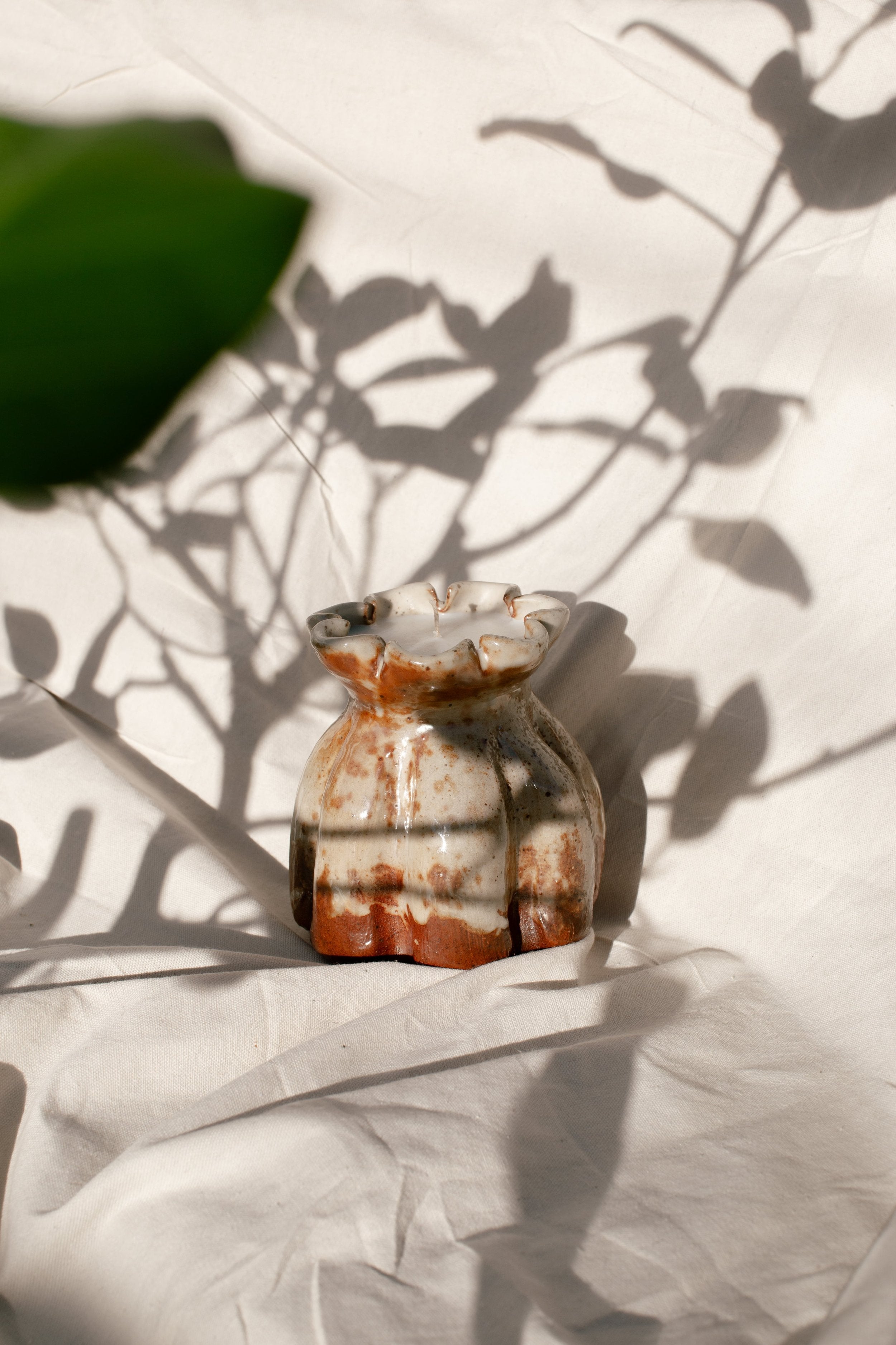 Ceramic Lotus Vase- H&G x Western Disco Candle Collaboration displayed on a textured surface with plant shadow, hommes + gardens estudio.