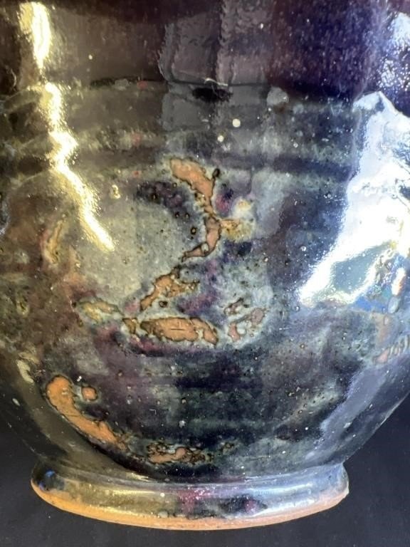 Close-up of a signed glazed stoneware bowl showcasing a unique glossy finish and abstract patterns, hommes + gardens estudio.