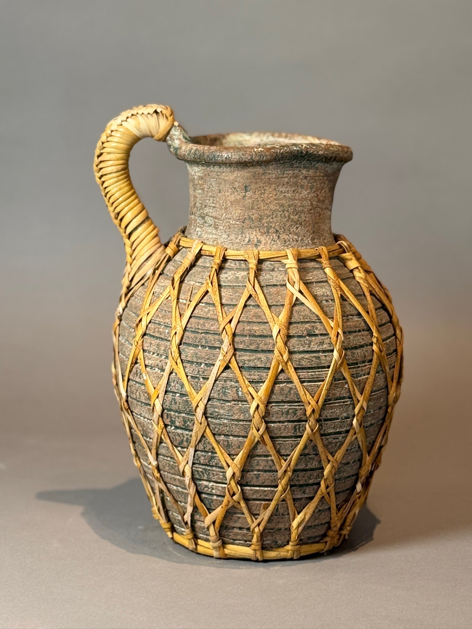 Vintage Woven Rattan Wrapped Vessel showcasing rustic charm and artisanal skill. Perfect for decor. hommes + gardens estudio