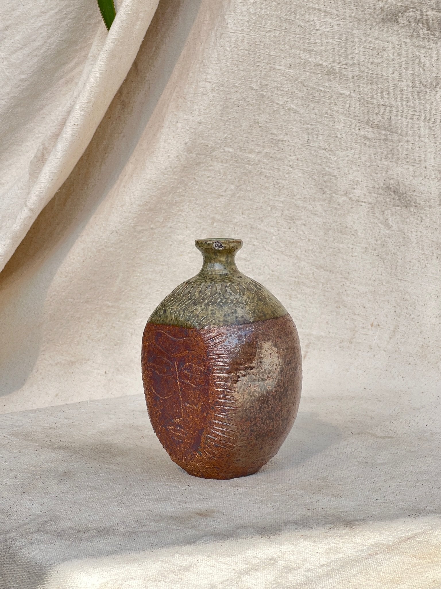 Handcrafted stoneware bud vase by E. Harris featuring engraved facial artwork and natural earthy tones — Hommes and Gardens, Vases + Vessels Collection, home decor, outdoor decorations, home design, luxury design, Landscape Architect, Interior Designer, Outdoor Living, Art, Furniture, Objects, Best Gifts, Nature, Backyard, Yard.