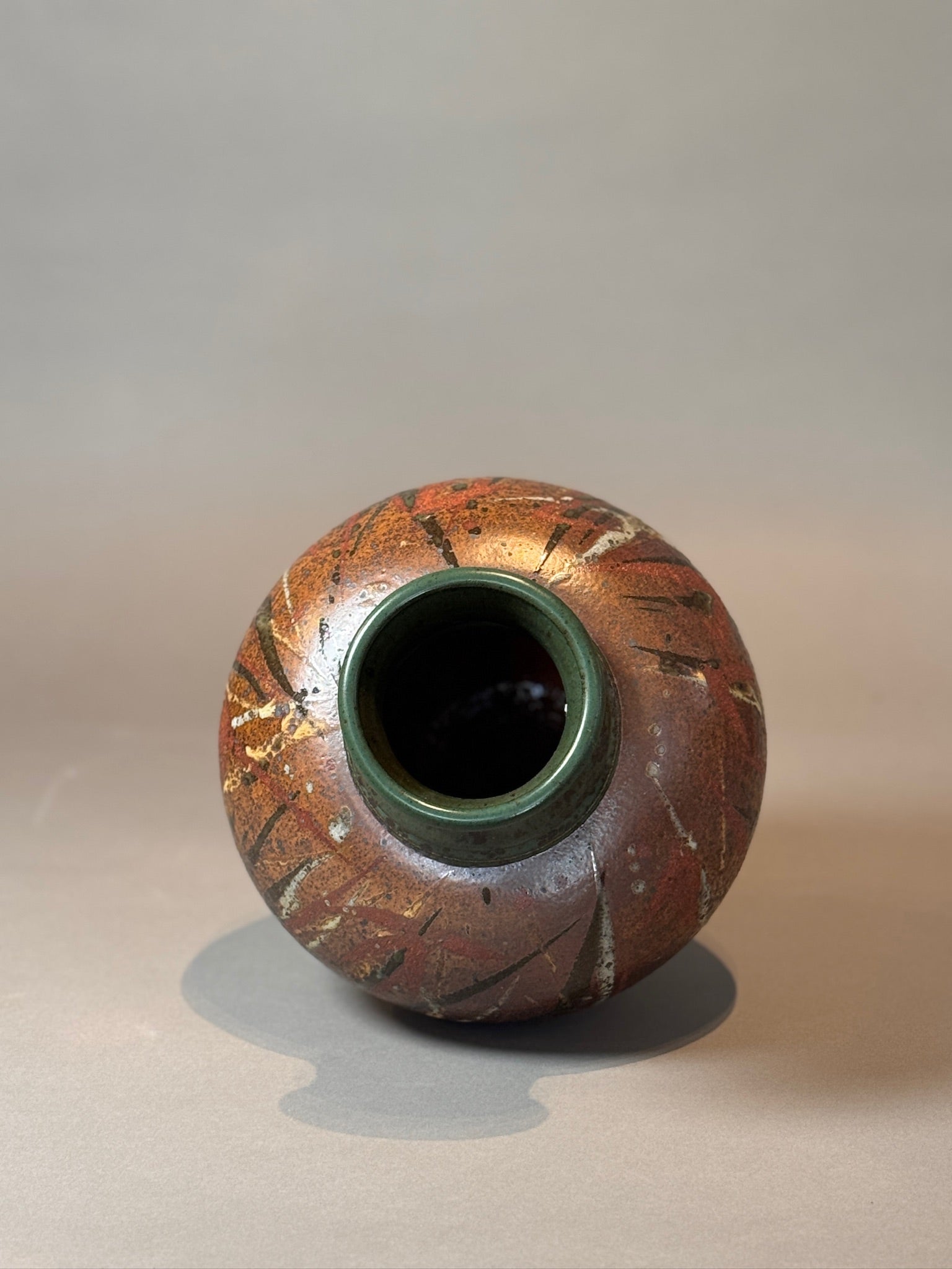 Signed Handcrafted Stoneware Vase with Rich Earthy Glaze showcasing its circular form and organic design. hommes + gardens estudio