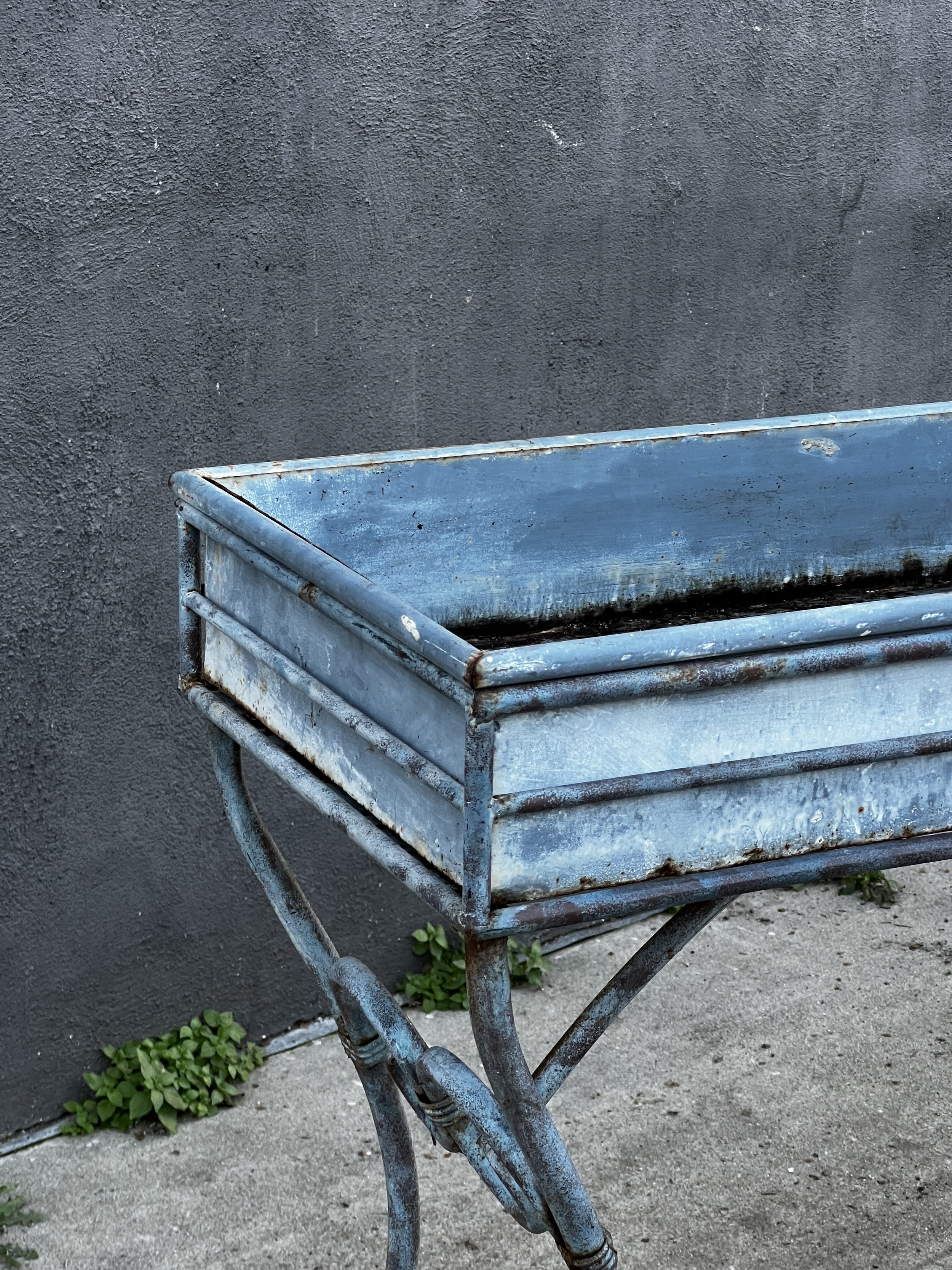Vintage Arras Style Tall Weathered Metal Plant Stand close-up showing weathered blue finish and elegant design. hommes + gardens estudio.