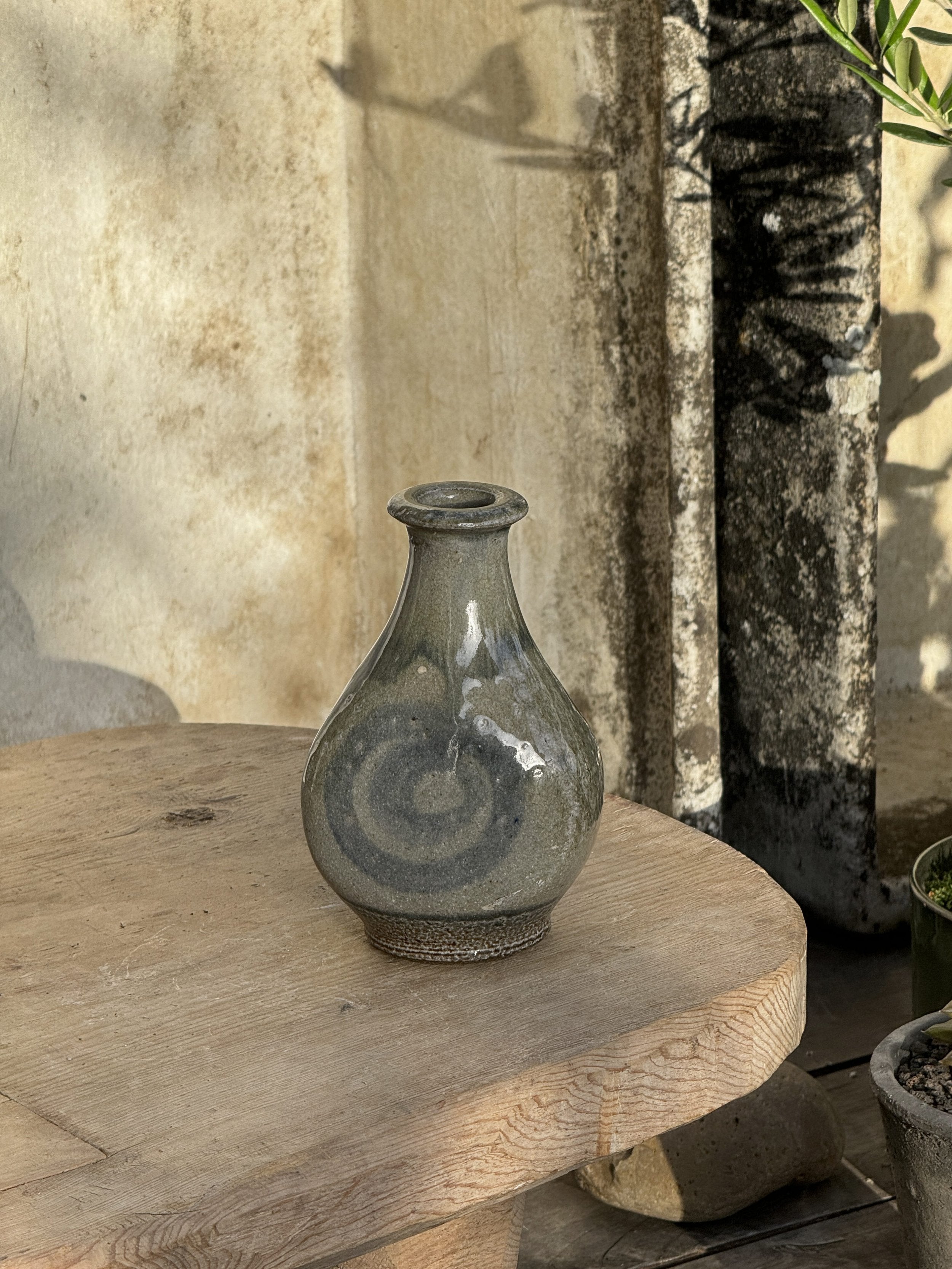 Vintage Glazed Spiral Studio Art Pottery Vase on a wooden table, showcasing its unique spiral design and gray hue. hommes + gardens estudio.