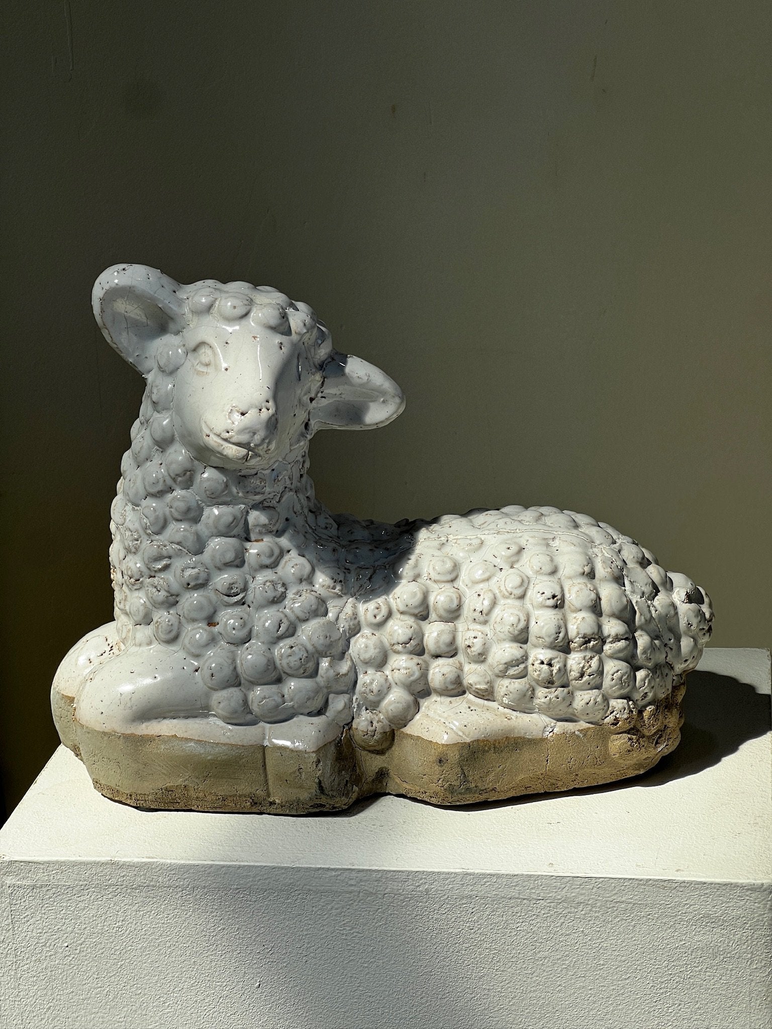 Vintage Laying Lamb Stoneware Figurine resting on a pedestal, showcasing vintage craftsmanship. hommes + gardens estudio.