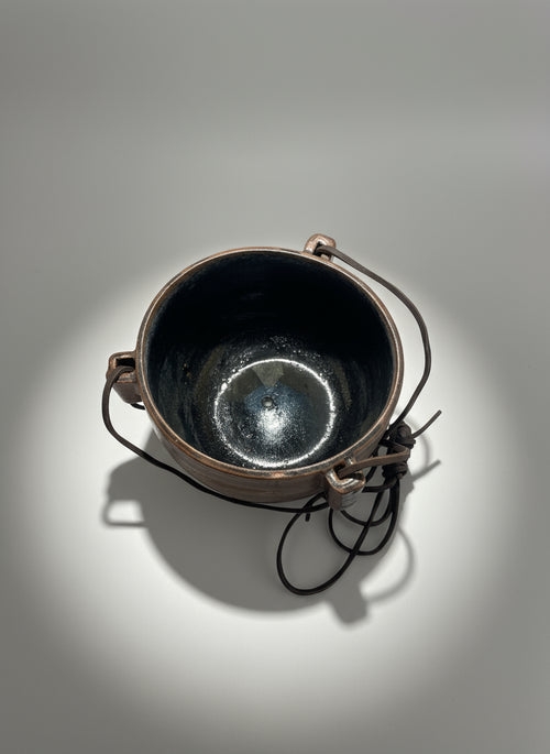 1972 Karroll Studio Pottery Hanging Planter – Rustic Ceramic with Leather, showcasing glossy black interior and rustic clay exterior. hommes + gardens estudio