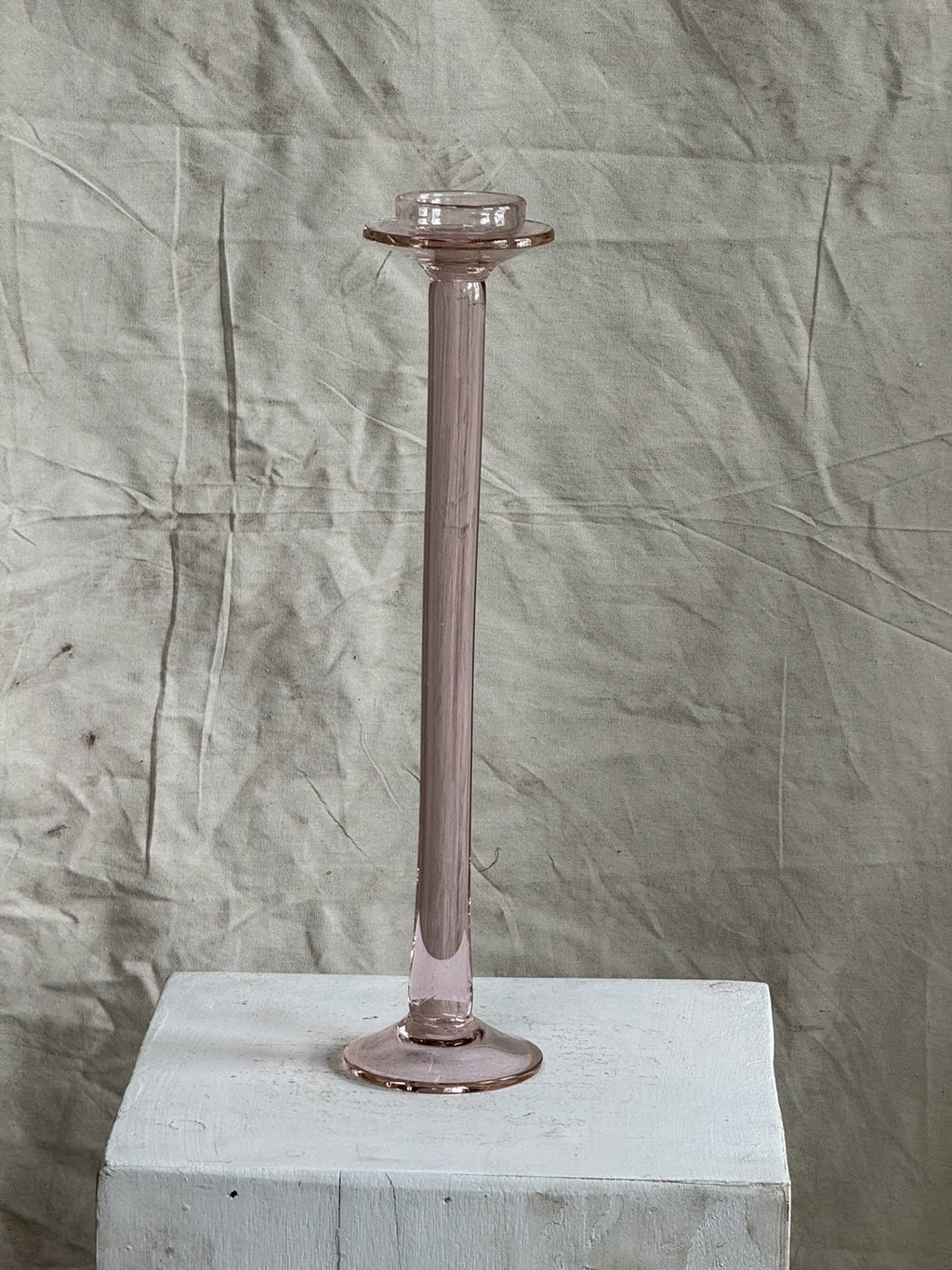 Vintage Pink Glass Candle Holder on a white pedestal, showcasing its elegant and nostalgic design. hommes + gardens estudio.