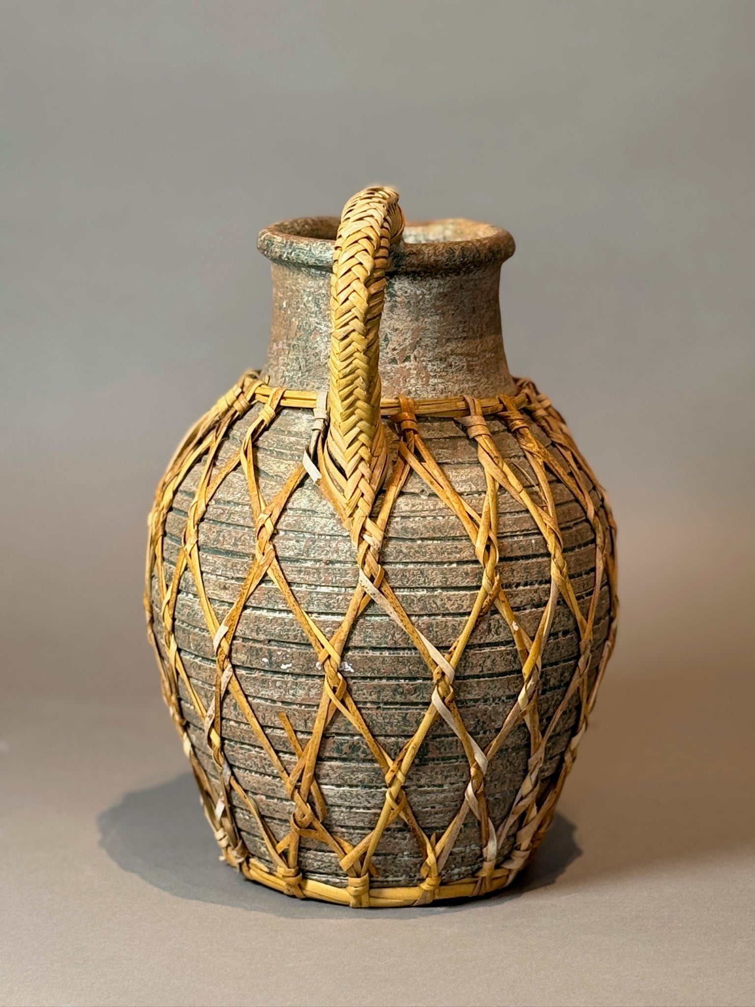 Vintage Woven Rattan Wrapped Vessel displaying organic rustic charm and artisanal skill. Perfect decorative accent. hommes + gardens estudio.