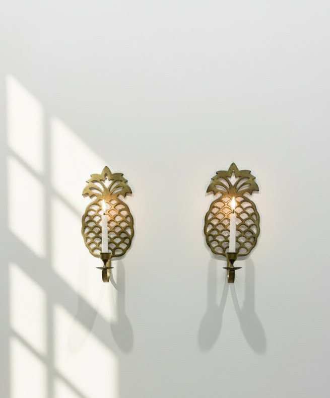 Pair of vintage brass pineapple wall candle sconces with intricate openwork detailing and golden patina, a timeless decorative set symbolising warmth and hospitality — Hommes and Gardens, Wallscape Collection, Smoke + Fire Collection, Home Decor, Landscape Architect, Interior Designer, Outdoor Living, Outdoor Decorations, Home Design, Luxury Design, Art, Furniture, Objects, Best Gifts, Nature, Backyard, Yard.